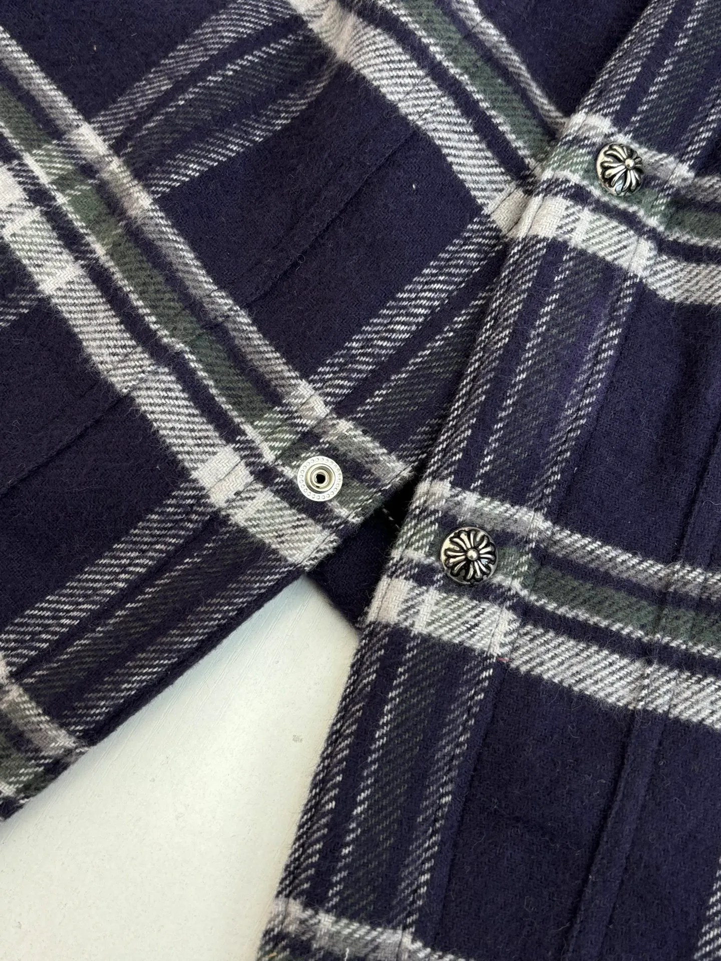 P670 Chrome Heart*/Chrome Heart Contrast Plaid Lapel Shirt Jacket. The fabric is made of 100% cotton fabric to create a navy blue main tone plaid. The rough plaid lines blend into the brand's iconic Gothic rebellious gene. The stiff cotton material supports the street silhouette, and the plush fabric inside adds softness and warmth. The collision of cold silver hardware and soft and warm inner wear is the dark aesthetic of Chrome Hearts' "symbiosis of hard core and gentleness". The autumn and winter layering has its own rock and roll accent.  Size：S/M/L/XL